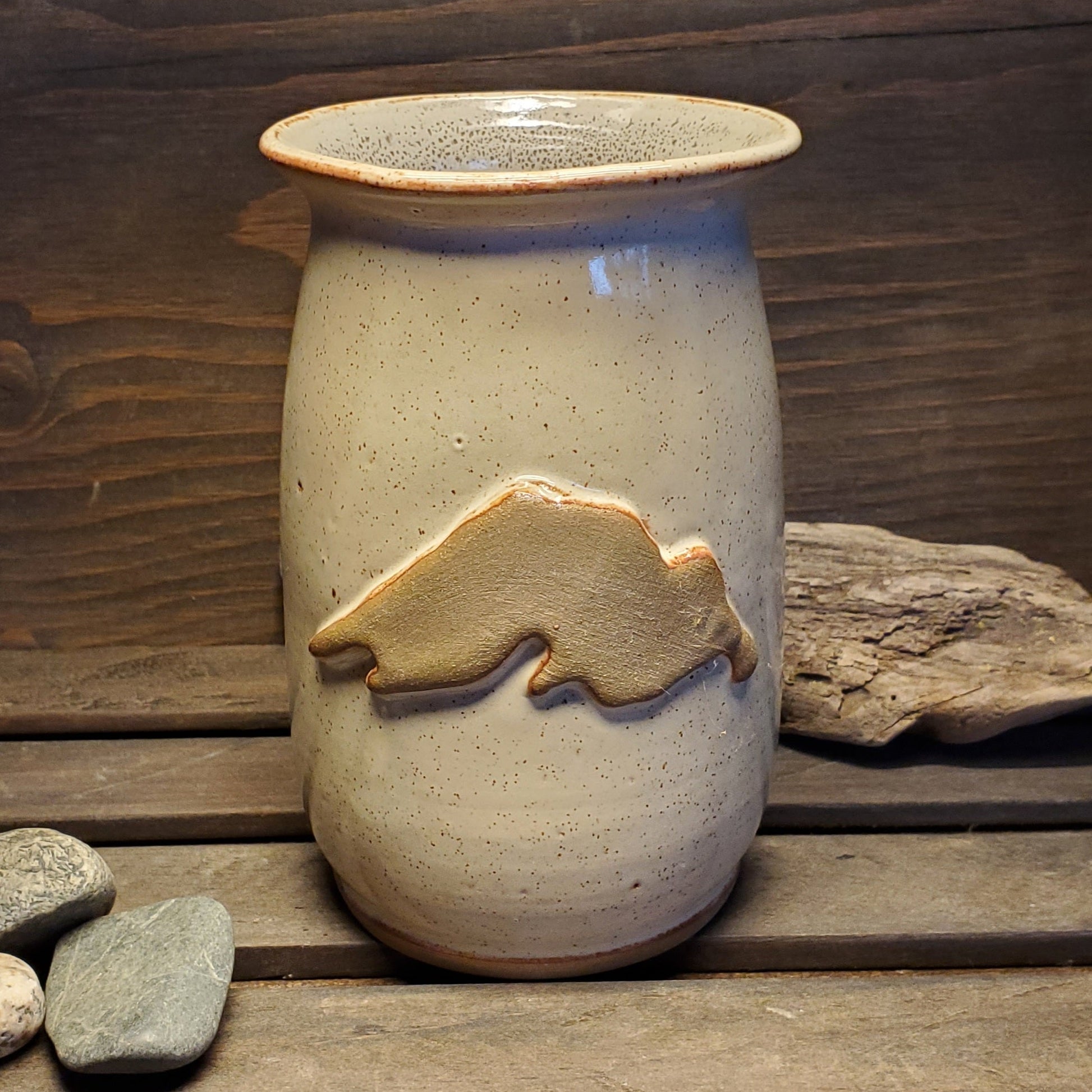 A white and brown hand made pottery vase with a tan Lake Superior.