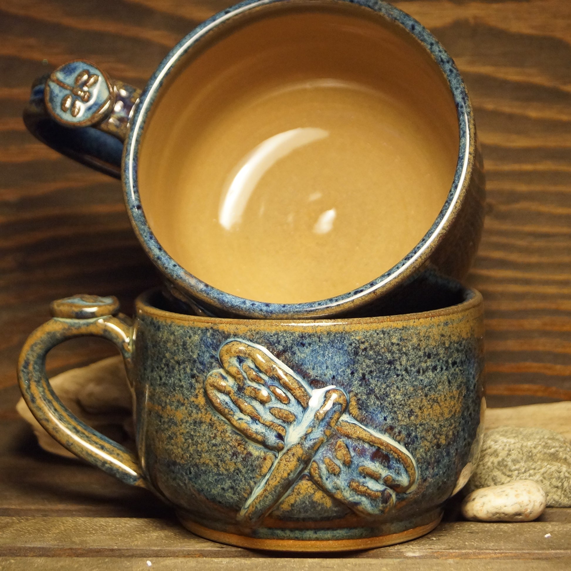 A blue and brown hand made chilli or soup mug with a dragonfly design.